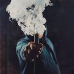 Vaper holding e cigarette with vapour cloud