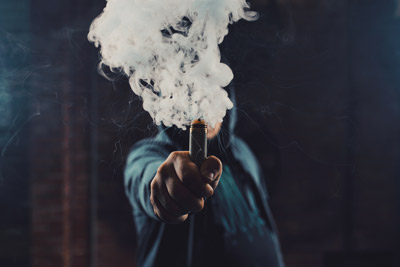 Vaper holding e cigarette with vapour cloud